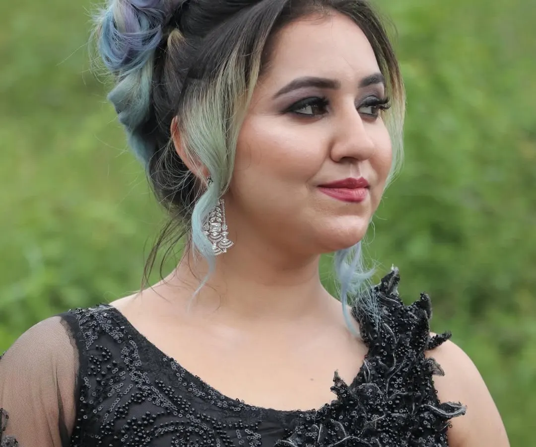 This elegant updo combines a classic bun with a modern twist of blue and lavender hair color. It's a perfect example of a festive hairstyle for parties or receptions, showing how color can be woven into sophisticated looks.