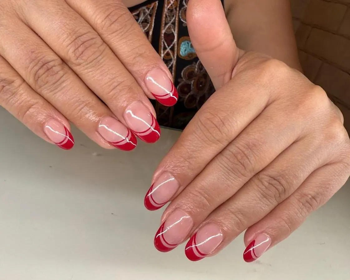 A modern twist on a classic. This double French manicure uses a bold red and clean white lines on a natural base for a chic and sophisticated look.