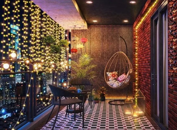This city balcony becomes a magical retreat at night with a canopy of fairy lights. We used patterned floor tiles, a comfortable swing chair, and brick-textured walls to create a bohemian-inspired space perfect for enjoying the evening view.