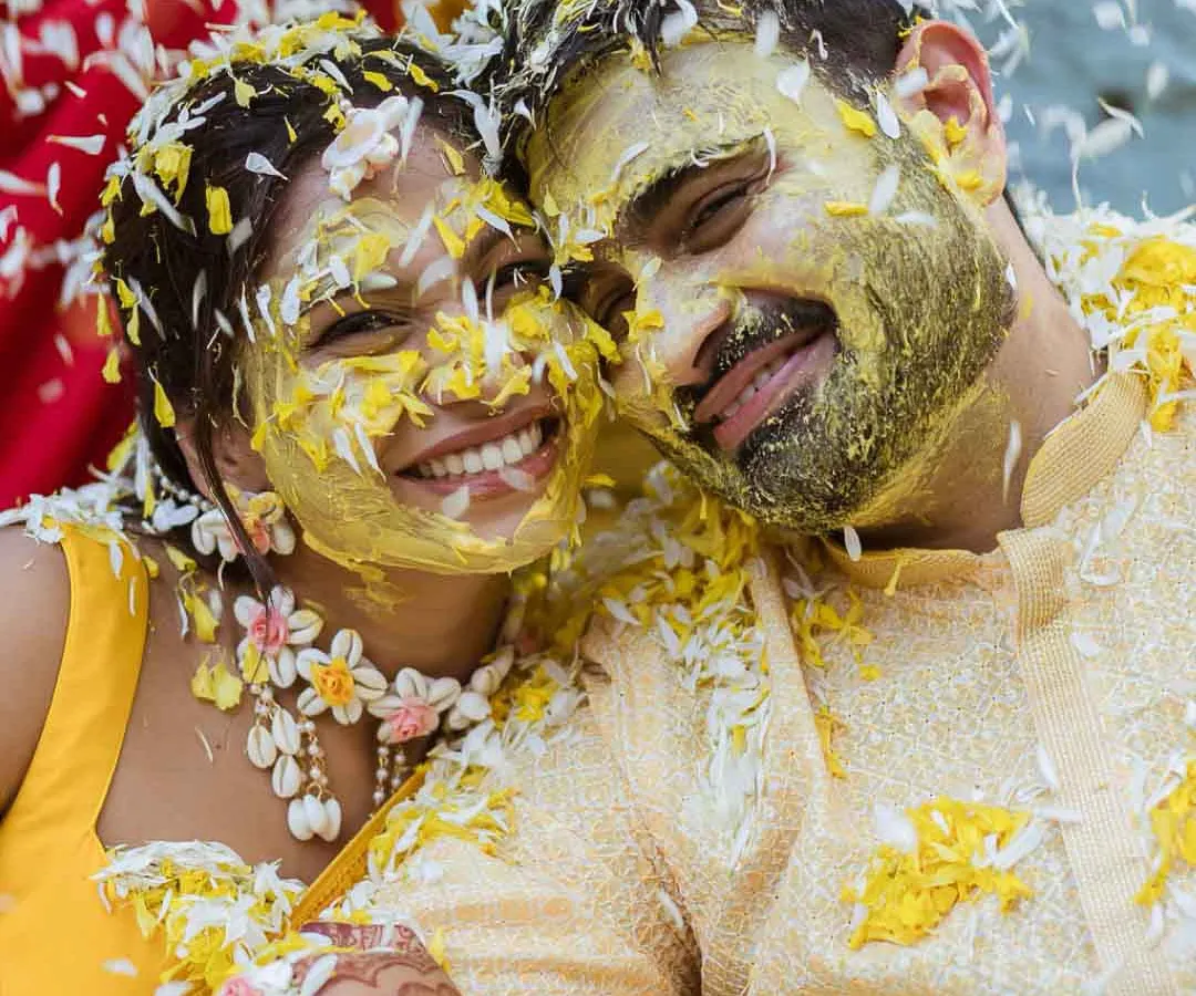 This is what pure joy looks like. I live for these unscripted moments during the Haldi ceremony, where the couple is just lost in laughter, covered in turmeric and flower petals. It's candid, vibrant, and absolutely real.