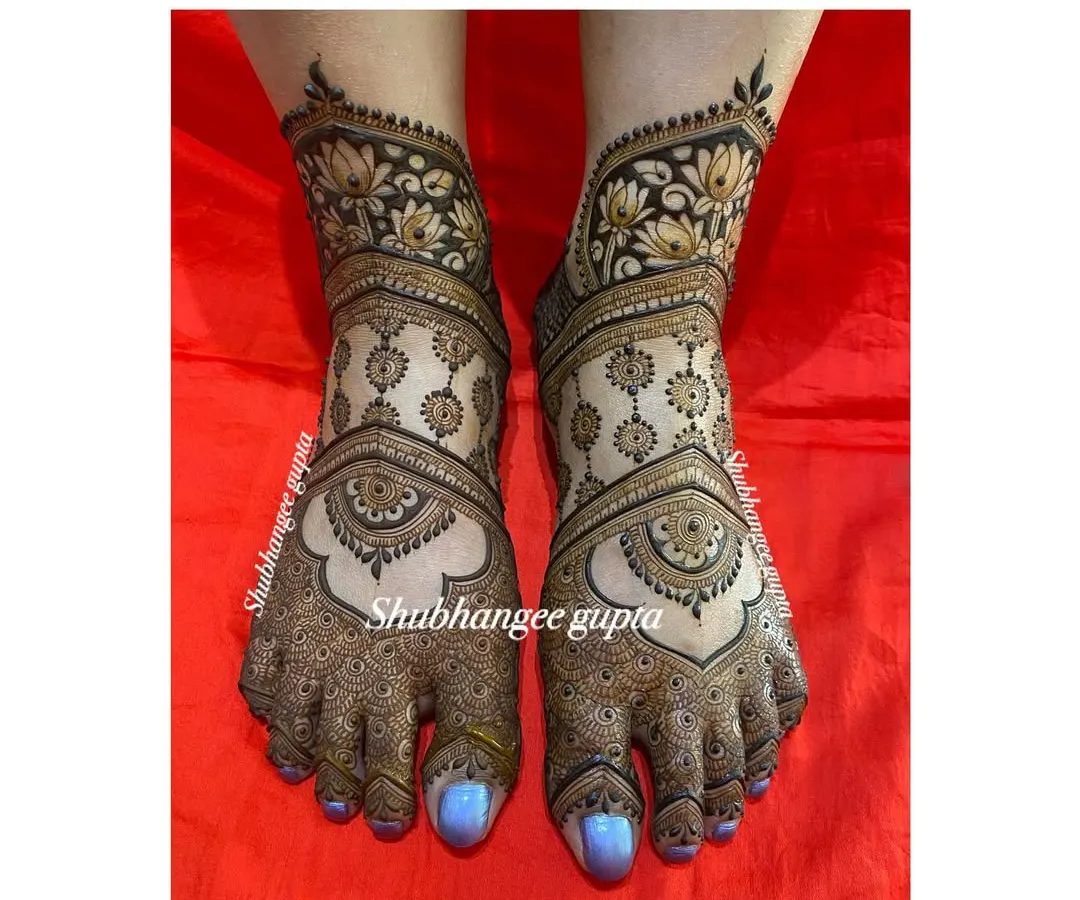 Your bridal look isn't complete without beautiful mehndi on your feet. This symmetrical design features delicate mandalas on the top of the feet and rich lotus patterns around the ankles, creating a balanced and elegant look for your wedding day.