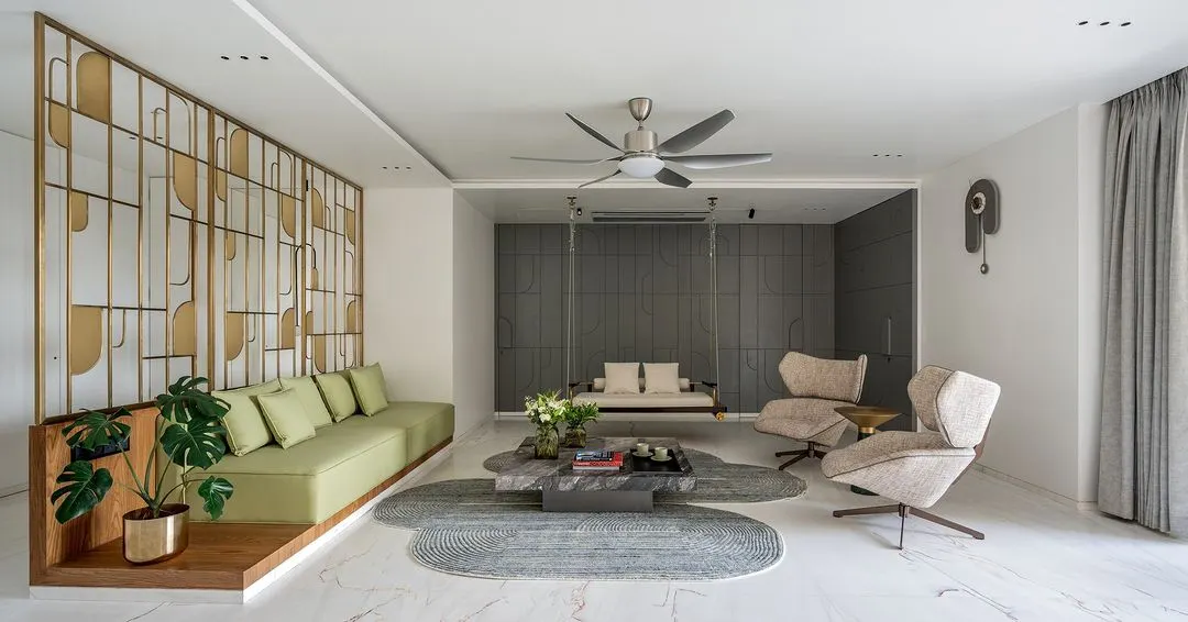 This formal living space from my Park West project embodies my design philosophy of creating tranquil, sophisticated environments. I used a layered neutral palette, punctuated by the soft green of the sofa and the warmth of a custom brass partition, to create distinct zones that flow into one another. The indoor swing adds a touch of playful serenity, making the space feel both grand and intimately personal.