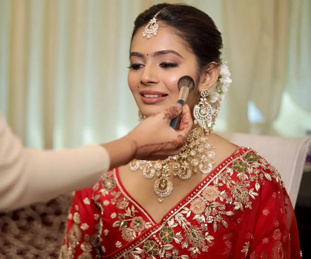 A close-up of my skin-focused technique. I believe in enhancing, not hiding. Here, I'm applying a light dusting of powder to set the makeup, ensuring the bride's natural skin texture and glow remain the hero of her wedding day look.