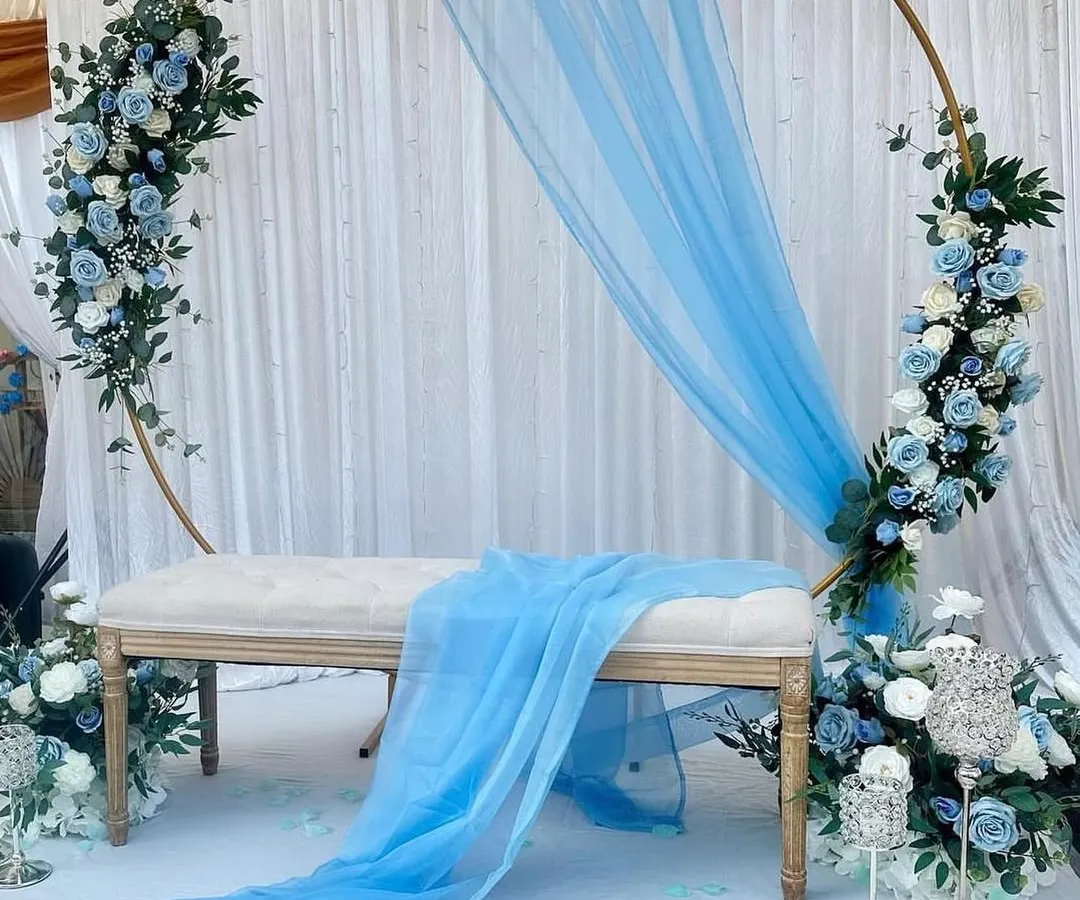 Here’s how we use color to create a specific mood. This serene blue and white theme is perfect for a baby shower, naming ceremony, or a sophisticated birthday. The light, airy fabric and delicate flowers on the circular frame create a truly dreamy atmosphere.