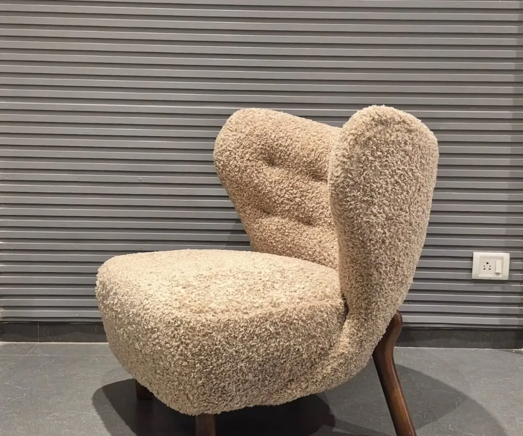 This is one of my favourite designs, a lounge chair upholstered in a beautiful bouclé fabric. The unique, sculptural form and solid wood legs make it a true statement piece for any living room or building lobby.