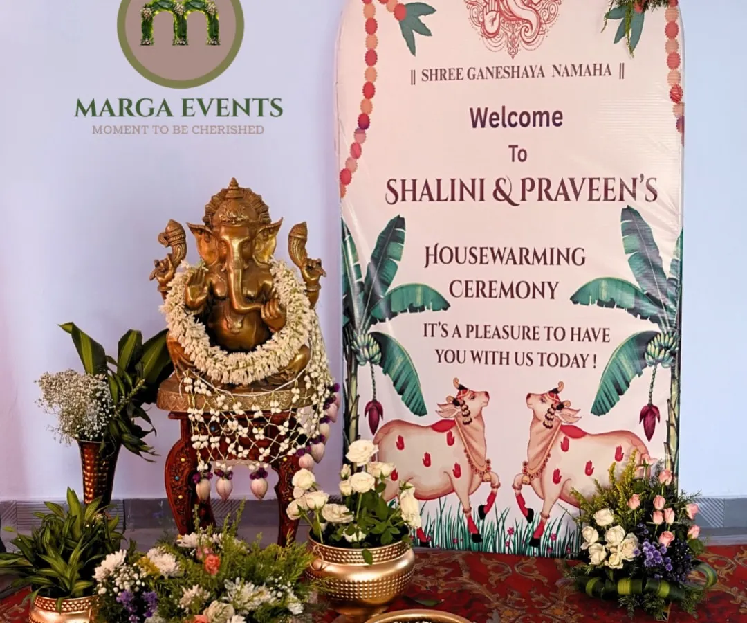 For this Gruhapravesham, I created a welcoming entrance that blends tradition with personal touches. The setup features a sacred Ganesha idol, fresh flower arrangements in brass urlis, and a custom banner to welcome Shalini and Praveen to their new home.