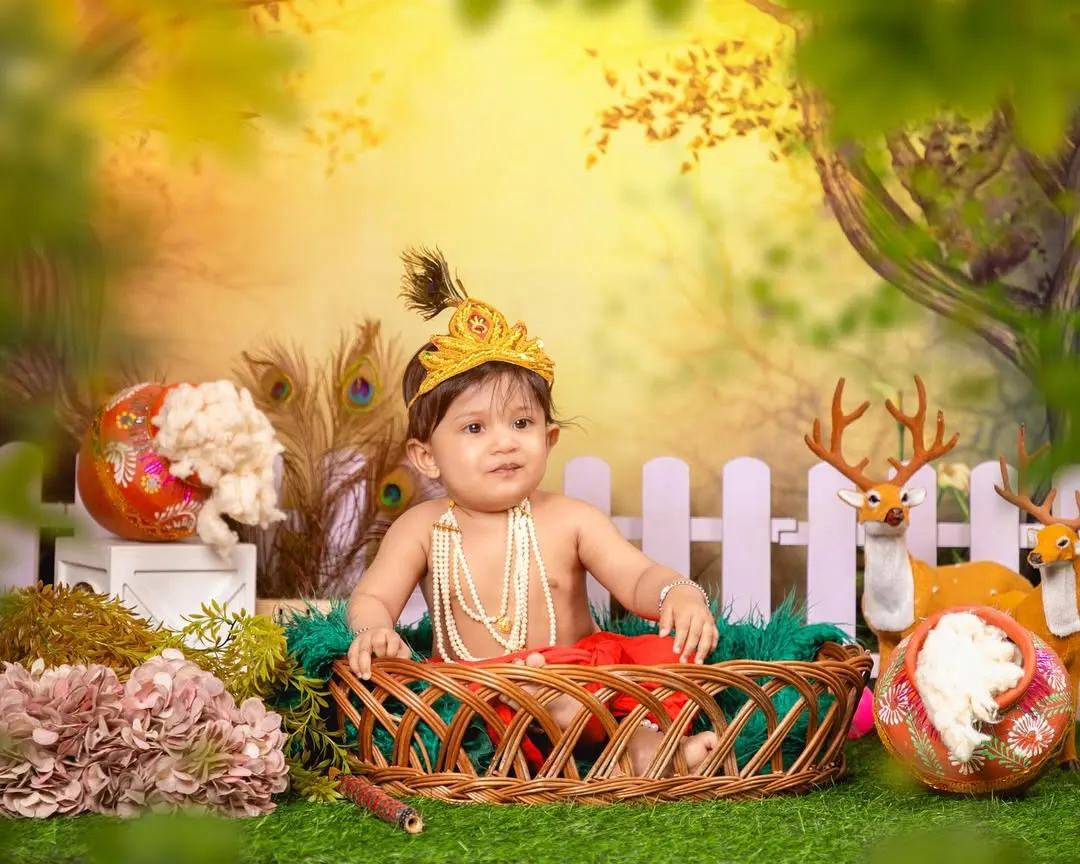 Celebrating tradition with a divine little Krishna photoshoot. I provide the complete setup, including the costume, peacock feather crown, and an enchanted garden backdrop, to create a truly special portrait for Janmashtami or any occasion.