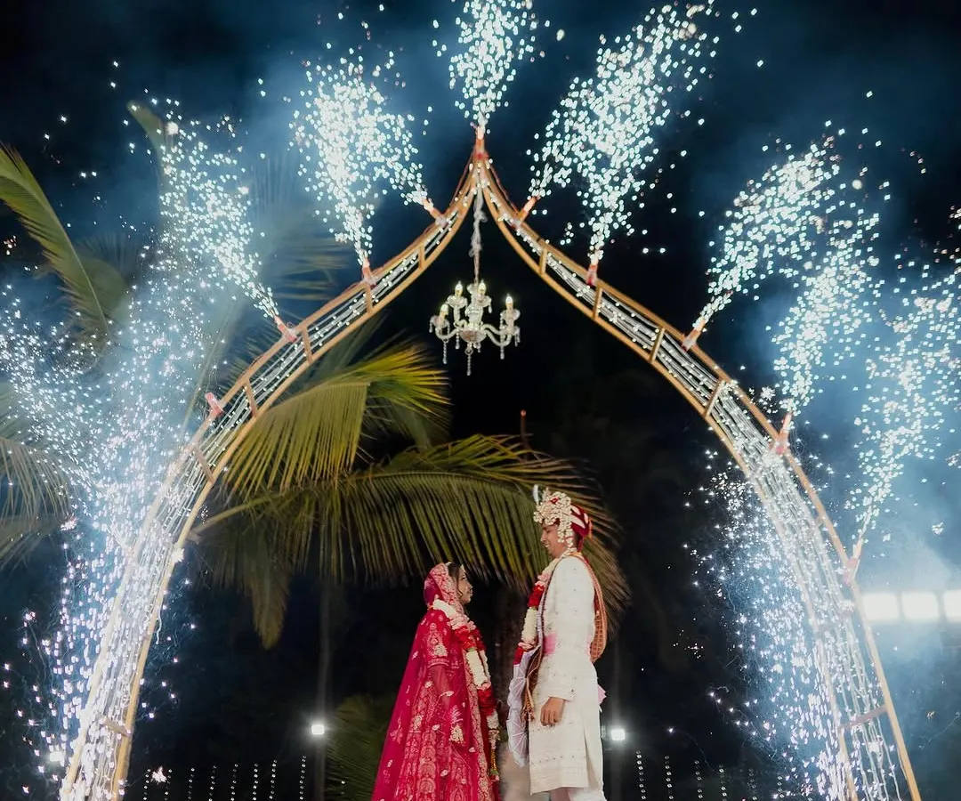 A moment of pure cinematic magic. We framed the couple's union under a grand arch, brought to life with a spectacular display of cold pyrotechnics. This design element adds a burst of excitement and grandeur, ensuring the wedding photos are as dramatic and memorable as the moment itself.