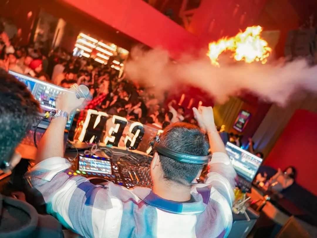 There's no feeling like being behind the decks, facing a sea of people, with the energy turned all the way up. This shot, with the pyrotechnics firing, captures the peak moment of a high-octane club night.