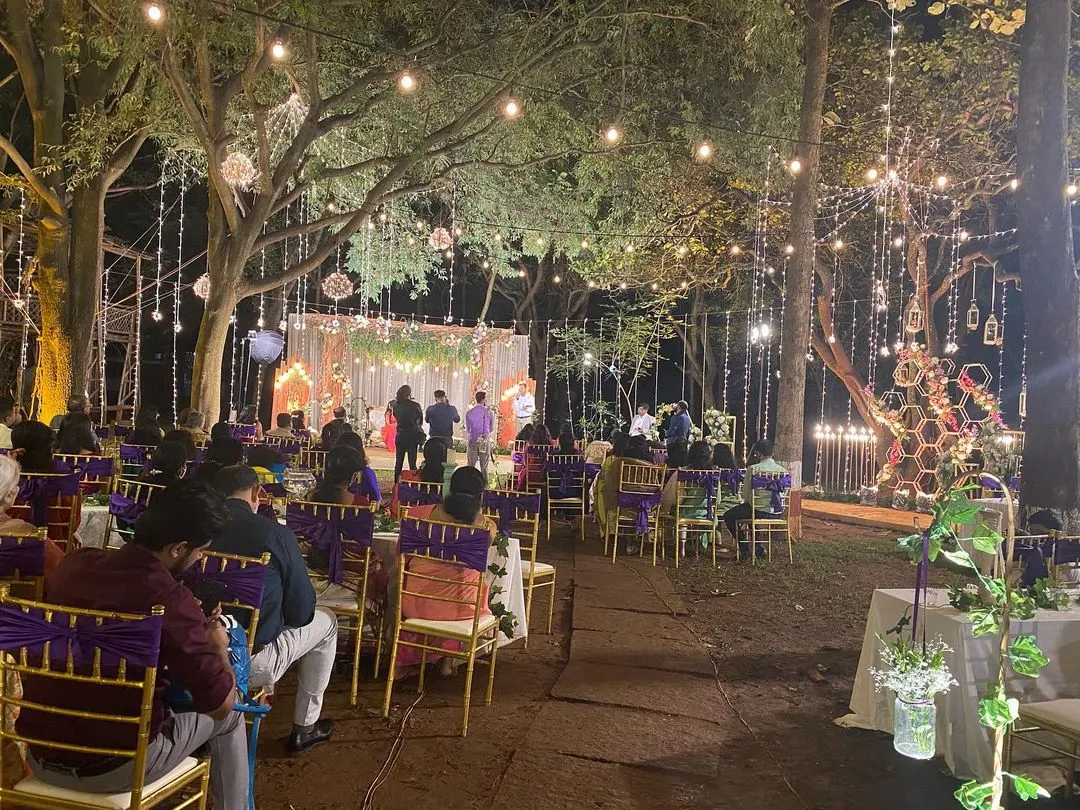An enchanting outdoor wedding reception at the Ecumenical Christian Center. We transformed the space with strings of Edison bulbs and hanging decor, creating a warm, rustic ambiance under the stars for a large gathering.
