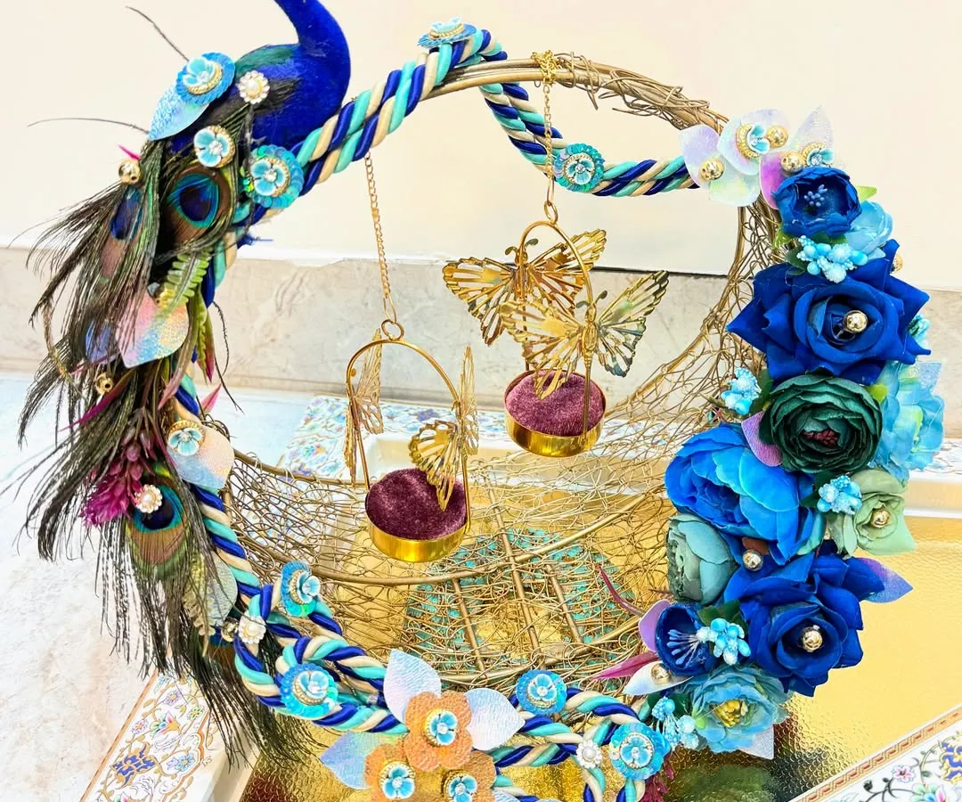 A ring platter should be as special as the moment itself. We designed this custom peacock-themed ring platter with vibrant blue florals and intricate feather details to create a royal stage for the rings. It’s a piece that truly celebrates the promise of a lifetime together.