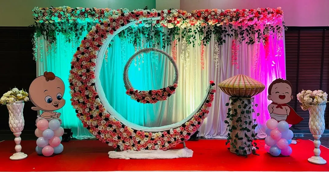 For a naming ceremony, I create magical setups like this one. The centerpiece is a large floral crescent moon holding a decorated baby palna, or cradle. This design makes the baby the star of the show and provides a beautiful backdrop for photos.
