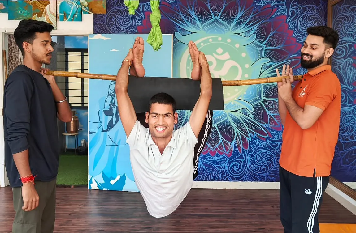 We creatively use props like this bamboo stick to help students safely explore advanced backbends. This method provides support while building the core strength and spinal flexibility needed for challenging asanas, making them accessible to more practitioners.