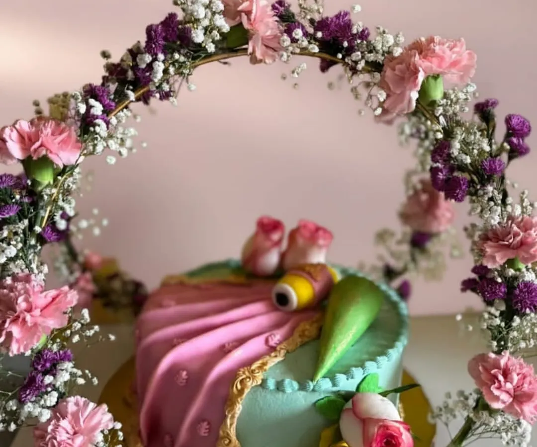 I designed this cake to look like an elegant saree, complete with a delicate floral arch. It was for a very special occasion, blending traditional art with modern baking. I used fresh cream and fondant to create the draping effect and intricate details.