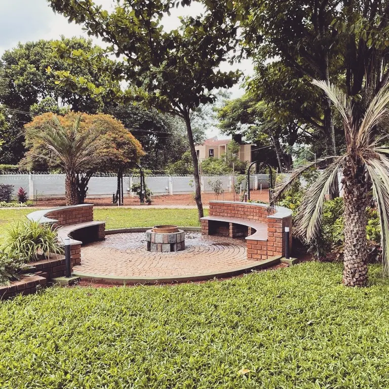 I designed this circular brick fire pit and seating area as the heart of a sprawling farmhouse landscape. It’s a perfect example of creating a warm, inviting social hub for family and friends to gather, surrounded by mature trees and open green space.