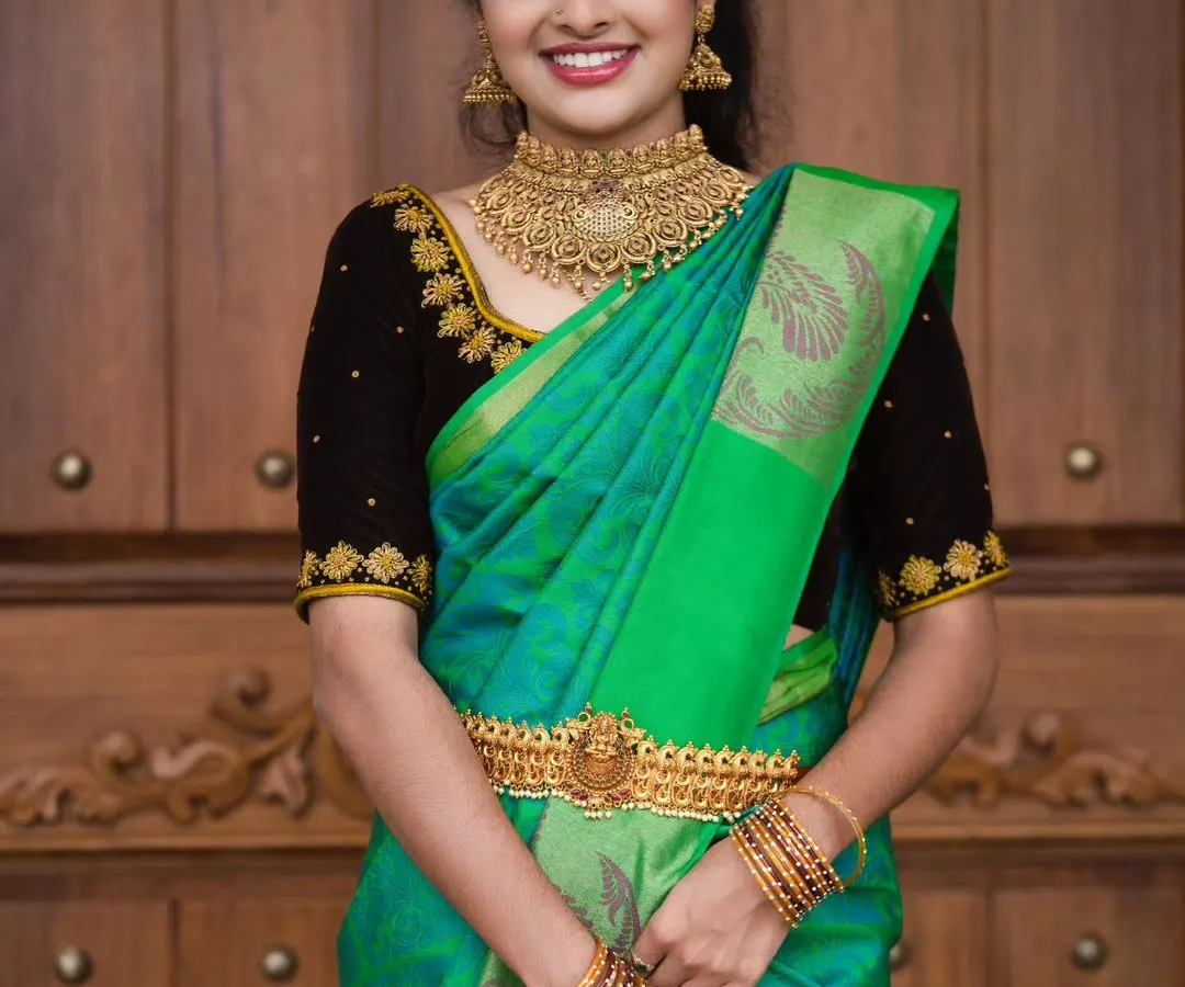 A happy bride is the most beautiful bride. For this look, we chose a warm, glowing makeup style with a soft smokey eye to match her vibrant green silk saree and gold choker necklace.