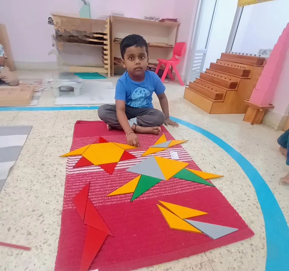 This is the essence of how we learn mathematics. A child explores geometry using the Montessori Constructive Triangles, discovering how shapes fit together not by memorizing rules, but through tangible, hands-on exploration.