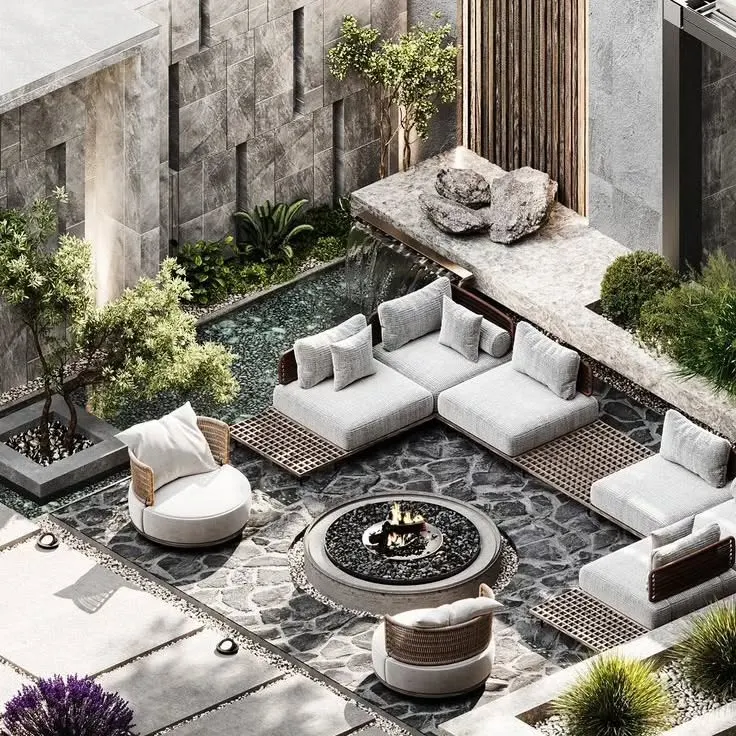 An isometric view of a modern sunken lounge concept, designed for intimate gatherings. This outdoor living space features a central fire pit, custom stone flooring, and integrated planters, all enclosed by a textured stone wall with a gentle water feature for ambient sound.