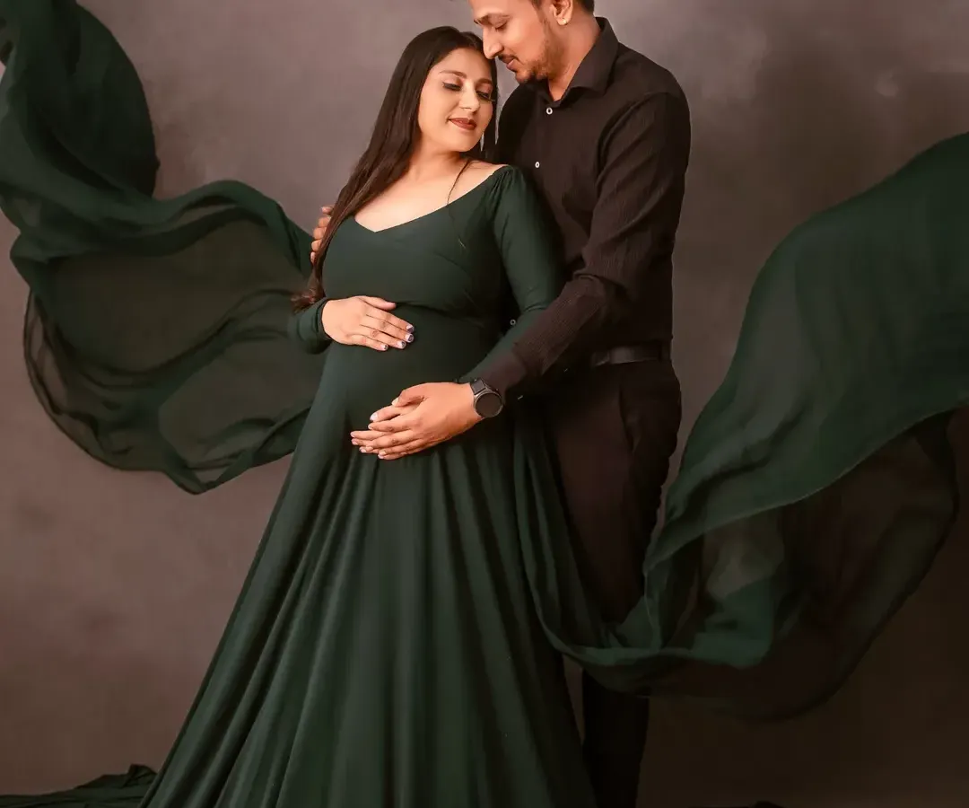 This is an example of my dramatic maternity photography. The deep green flowing gown and moody, textured background create a powerful, fine-art portrait for this expecting couple.