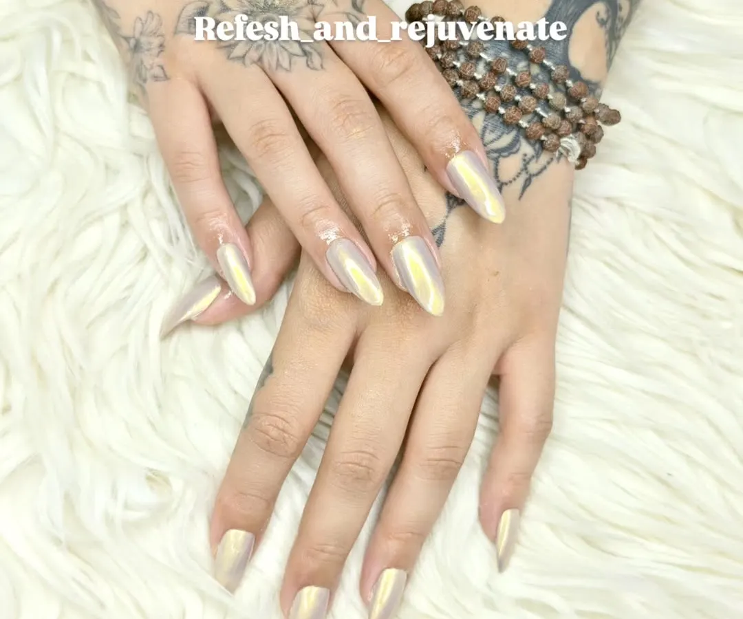 These stiletto nail extensions feature a stunning iridescent chrome finish that shifts in the light. This trendy and eye-catching look is perfect for anyone wanting a modern and high-fashion style.