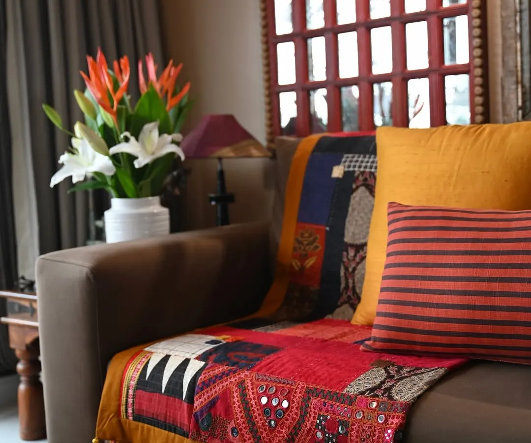 A sofa throw quilted entirely from scrap fabrics, inspired by the spontaneous beauty of Siddi Kawandi and Japanese Boro stitching. This piece celebrates my zero-waste philosophy, where every scrap has a story and a purpose. It features vintage Kutch embroidery and playful appliqué details, making it a truly one-of-a-kind textile artwork for the home.