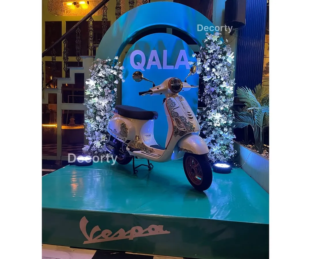 For the launch of Vespa's 'Qala' edition, I created a stunning display stage that put the product front and center. This setup combines elegant floral work with bold, illuminated branding to create a high-impact brand activation.
