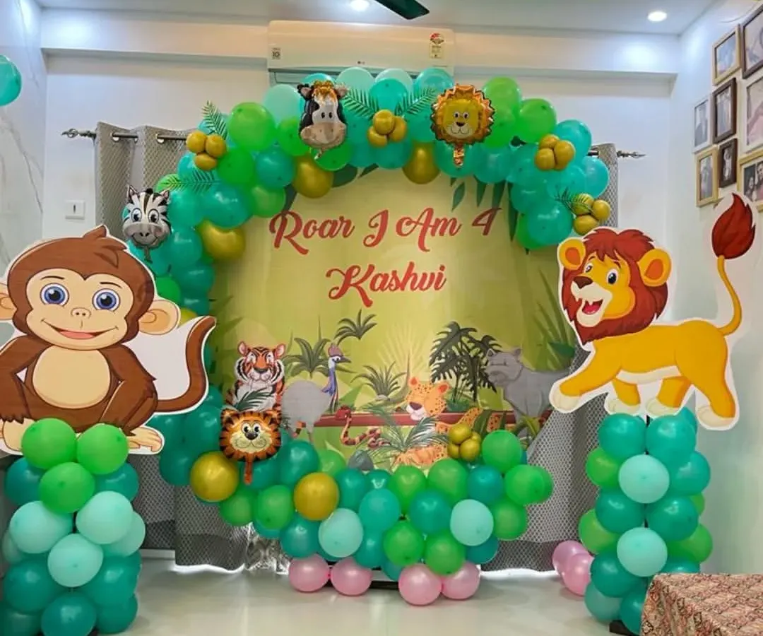 For kids' birthdays, I create fun, themed decorations like this jungle-inspired setup for a 4th birthday. It includes a full balloon arch in shades of green, a personalized backdrop, and large cutouts of favorite animal characters like a monkey and lion, making it a great photo spot.