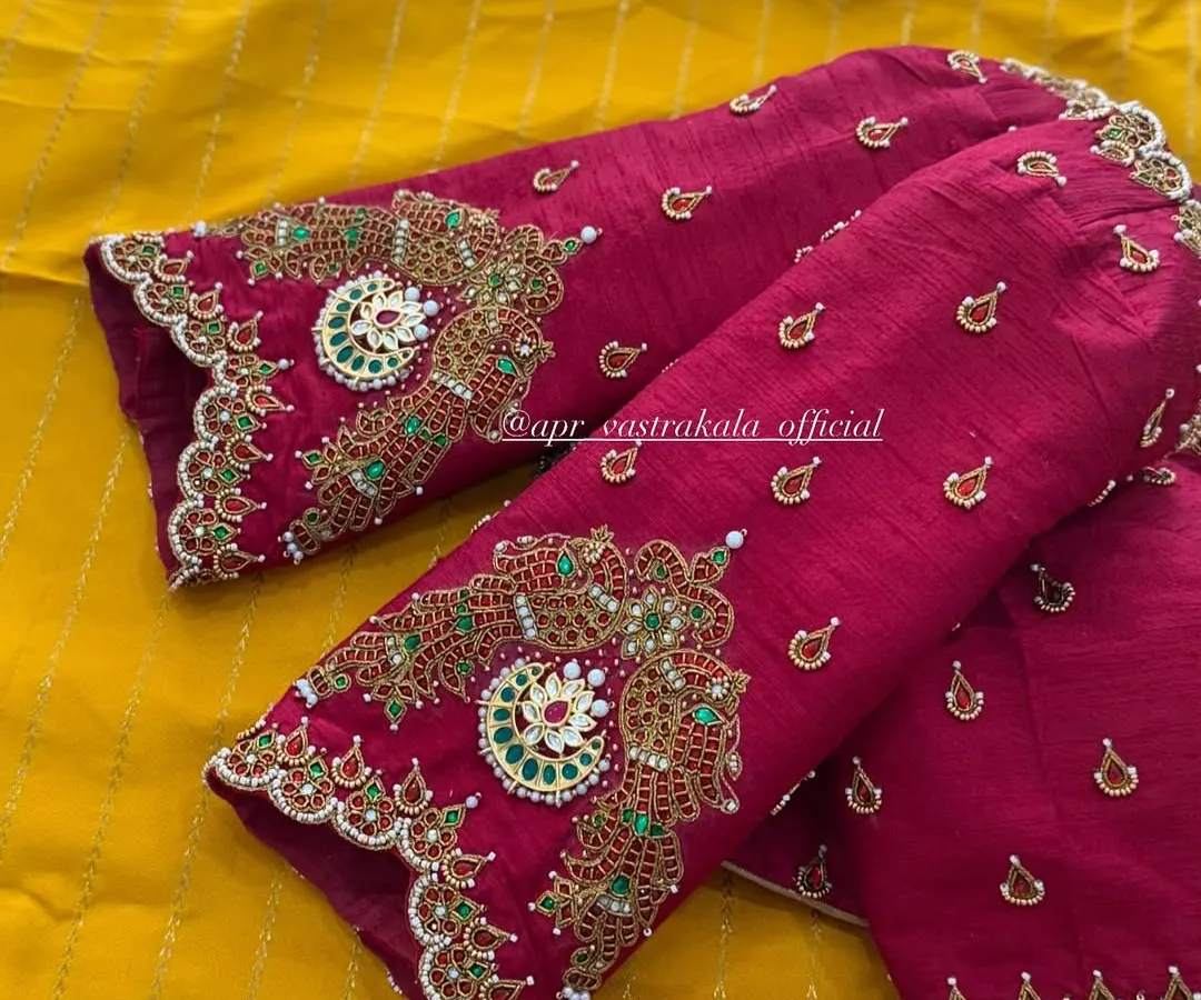 A close look at the detailed handwork on the elbow-length sleeves of a magenta raw silk blouse. This is my signature jewellery concept, where zardosi, kemp stones, and beadwork are combined to mimic the grandeur of a traditional necklace.