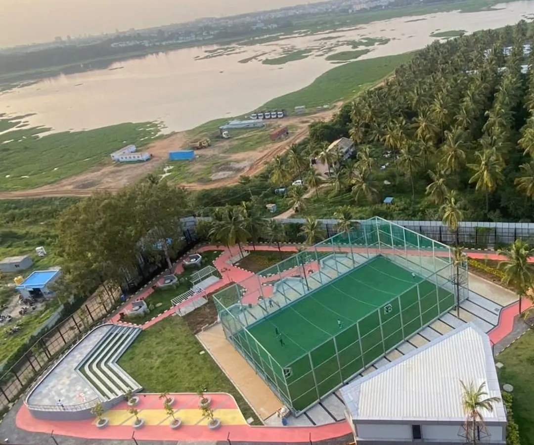 An aerial view of our completed work at Vaishnavi Tech Square, showing the integration of recreational facilities within the master plan. We designed a multi-sport court and an amphitheater overlooking the natural landscape, creating active zones for the community.