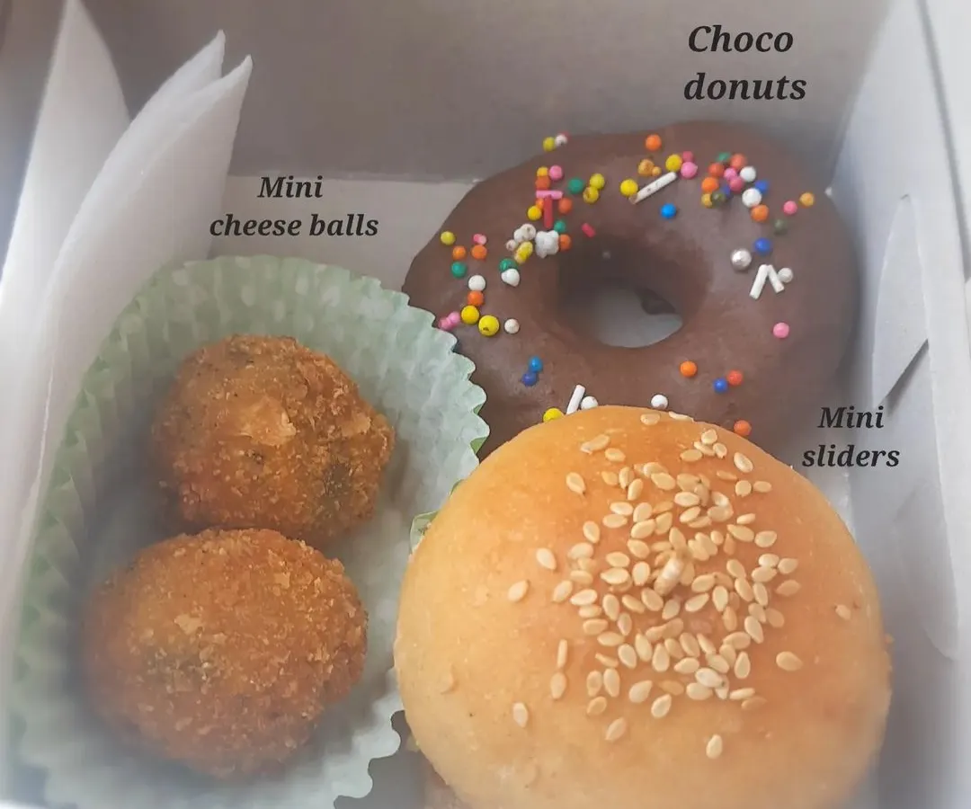 A peek inside one of my popular kids' party boxes. This one has mini sliders with homemade patties, mini cheese balls, and a choco donut, all perfectly portioned for little ones.