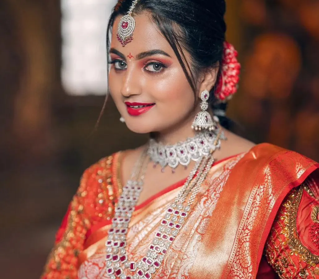 For a dazzling reception or engagement, this American diamond and ruby imitation set is a perfect choice. The intricate design features a statement choker and a layered long necklace, offering a modern yet grand look that is lightweight and comfortable.
