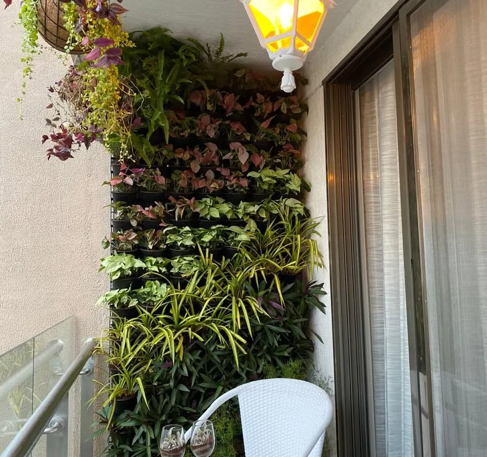 We transformed this compact apartment balcony into a cozy, private retreat. A dense vertical garden provides a lush green backdrop, perfectly complementing the small bistro table for a quiet evening with wine and conversation.
