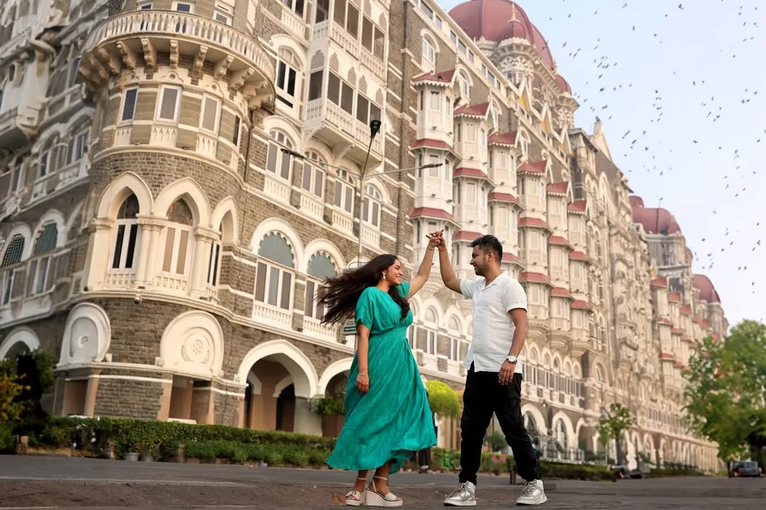 We use iconic locations like Mumbai's Taj Mahal Palace Hotel to create dramatic and memorable pre-wedding photographs. This shot captures a dynamic, joyful dance, turning a city landmark into a personal part of your story.