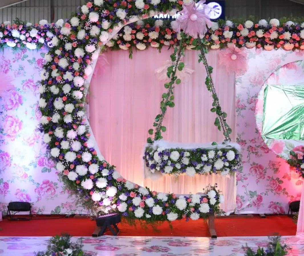 I love making naming ceremonies magical. This moon-shaped cradle design, adorned with a cascade of fresh flowers against a floral print backdrop, creates a dreamy setting to welcome a new baby.