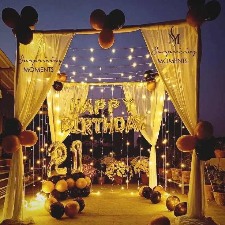 For a grand 21st birthday, I set up this stunning canopy on a terrace. The backdrop of fairy lights, gold "HAPPY BIRTHDAY" balloons, and a black and gold theme made for an unforgettable outdoor celebration.