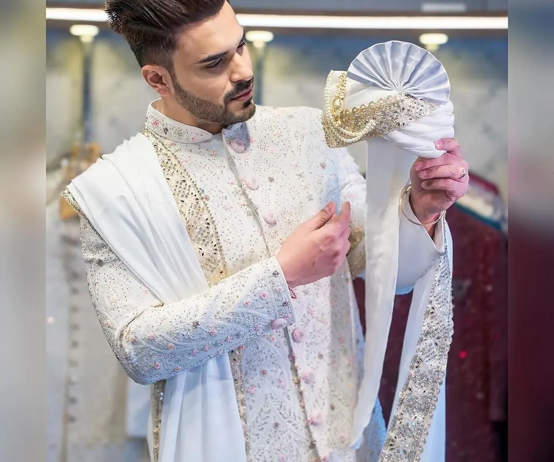 A groom's attire should be nothing short of magnificent. Here, influencer Ayush Khatri is seen during a fitting for his custom sherwani, a masterpiece of intricate embroidery and regal design, complete with a matching turban and stole.