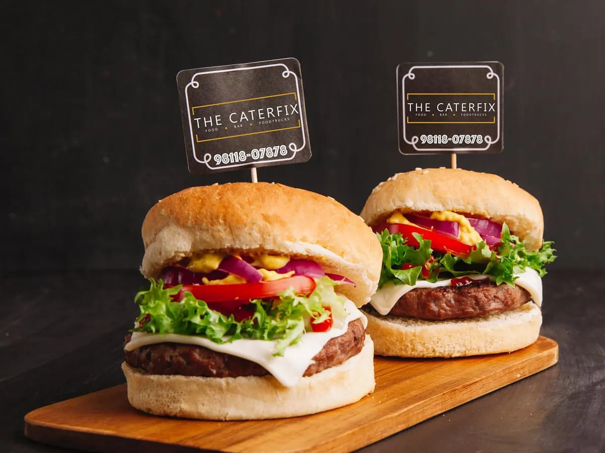 I serve up juicy, gourmet burgers that are always a hit. Each one is made with a perfectly cooked patty, fresh lettuce, ripe tomatoes, and cheese, all tucked into a soft bun. It's a classic party food, elevated.