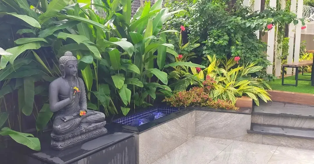 This is a recently completed tropical garden landscaping project. We incorporated a tranquil Buddha statue and a small water feature alongside lush foliage like Calathea and flowering bushes to create a complete, sensory garden experience.