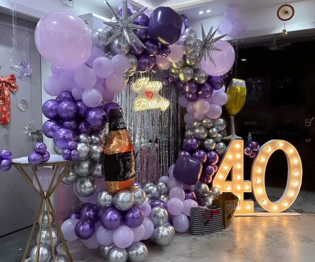 I designed this complete setup for a 40th birthday party. It includes a circular balloon arch, a silver fringe curtain, a custom neon sign, and large marquee numbers for a stylish photo backdrop.