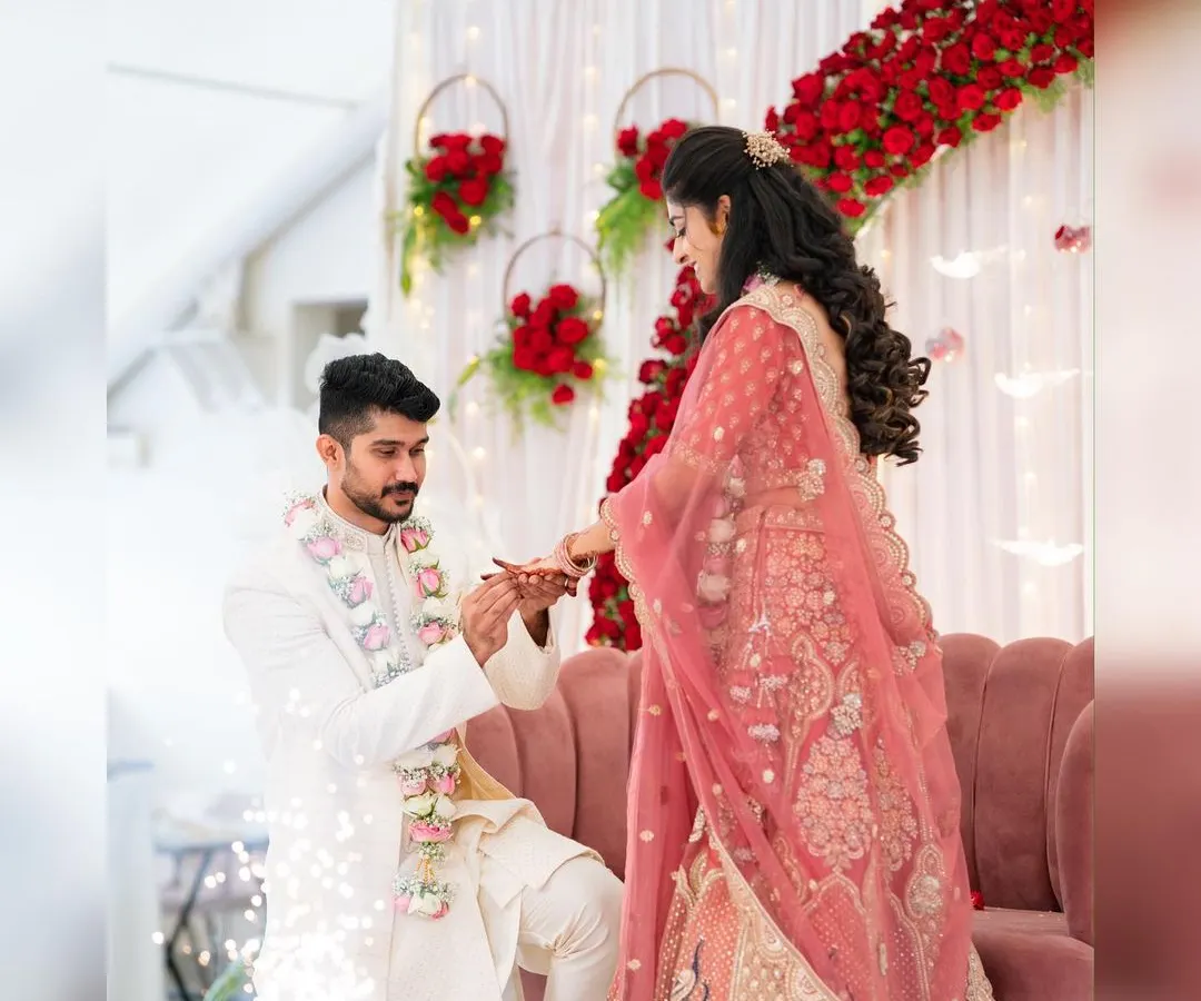 This is a moment that deserves the perfect setting. For this engagement, we created a romantic backdrop with a dense wall of red roses, elegant white drapes, and hanging floral hoops, complete with cold pyro effects for that extra sparkle.