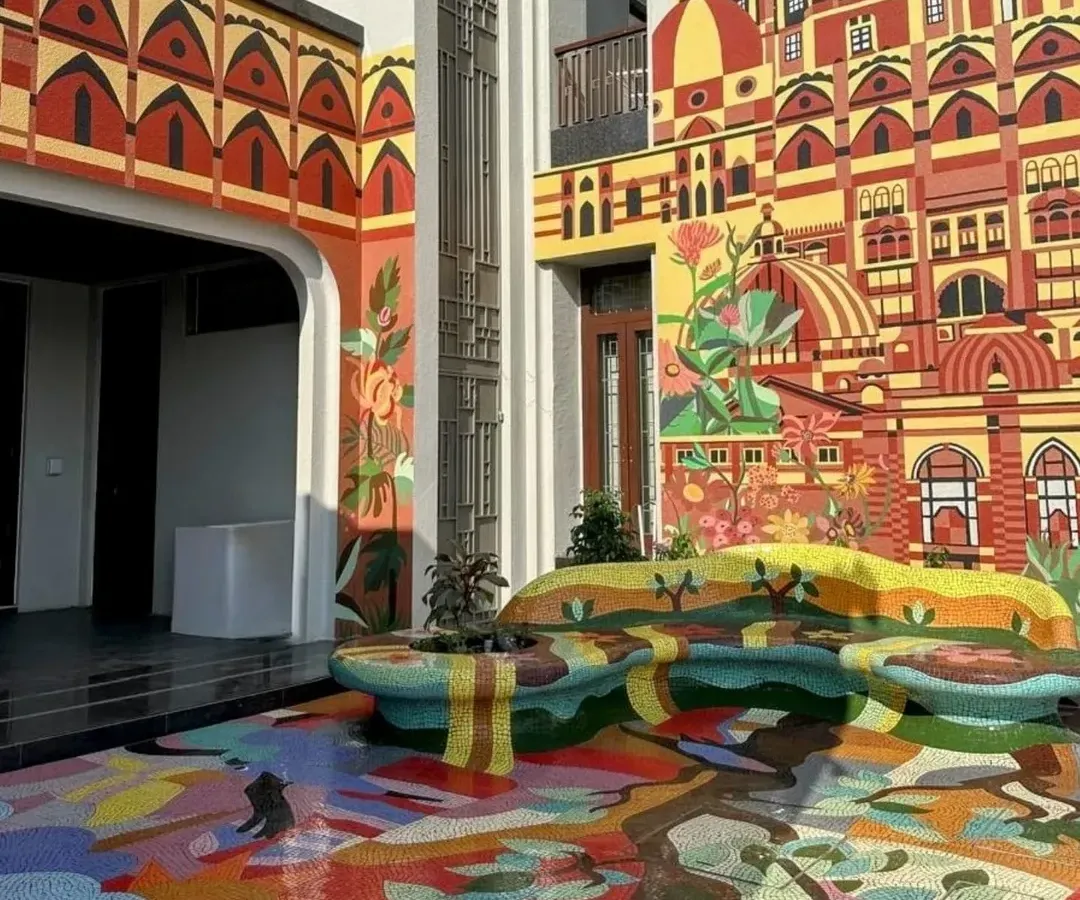 Here, art spills from the walls onto the floor and becomes furniture itself. This residential courtyard in Rajkot features a vibrant, hand-laid floor mosaic and integrated sculptural seating, creating a completely immersive, functional art experience.