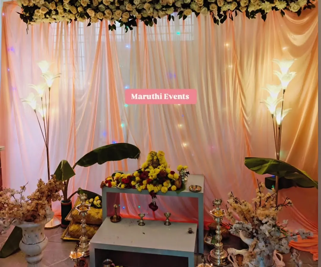 For a Gauri Maa puja, I designed this elegant and serene setup. It includes a beautiful floral arrangement overhead, soft peach drapery with subtle lighting, traditional banana leaves, and floor lamps to create a warm, divine atmosphere.