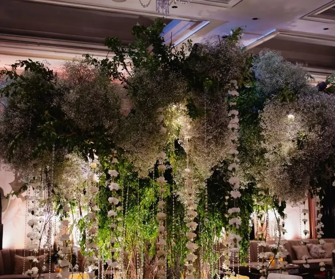 We brought the outdoors in for this stunning reception, centered around an iconic floral tree. Draped in baby's breath and crystal hangings, and surrounded by hundreds of candles, this installation transformed the ballroom into an enchanted forest.