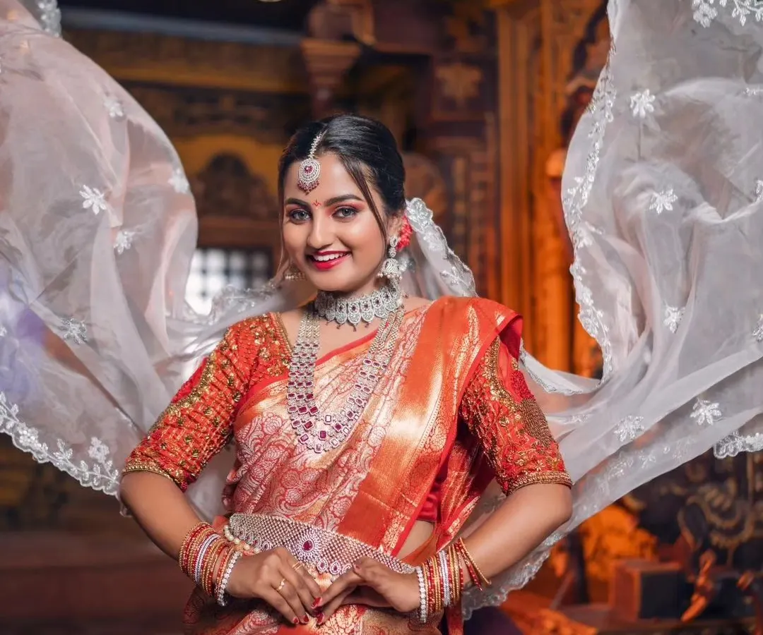 Make a grand entrance at your reception with this breathtaking diamond-look jewellery set. The intricate design, featuring a statement necklace and matching vaddanam, ensures you will sparkle all evening.