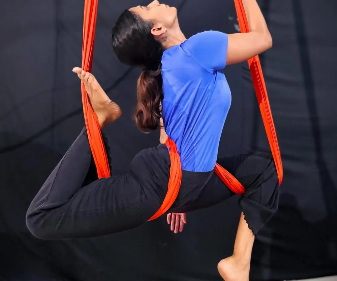 Aerial yoga is not just about flexibility, it's about finding balance and poise while suspended in air. This beautiful pose on the aerial hammock shows the artistry and control our adult students develop in their practice.