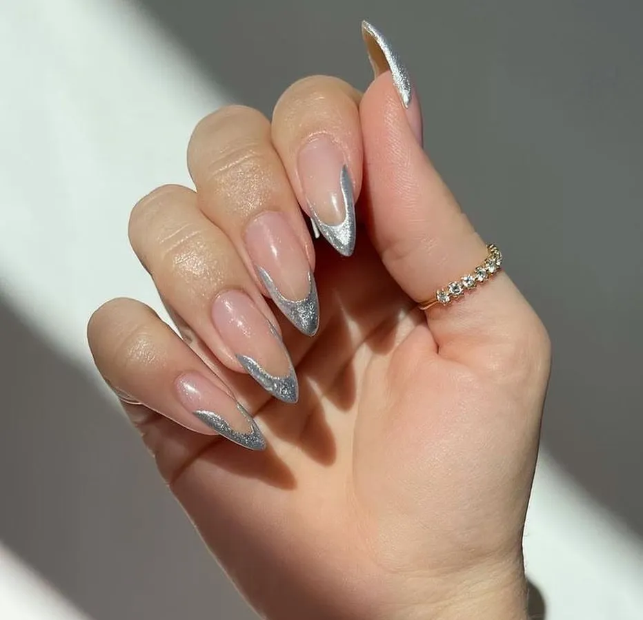 This is my modern take on a classic. A sharp, silver glitter French tip on perfectly shaped almond extensions for a look that is both elegant and glamorous.