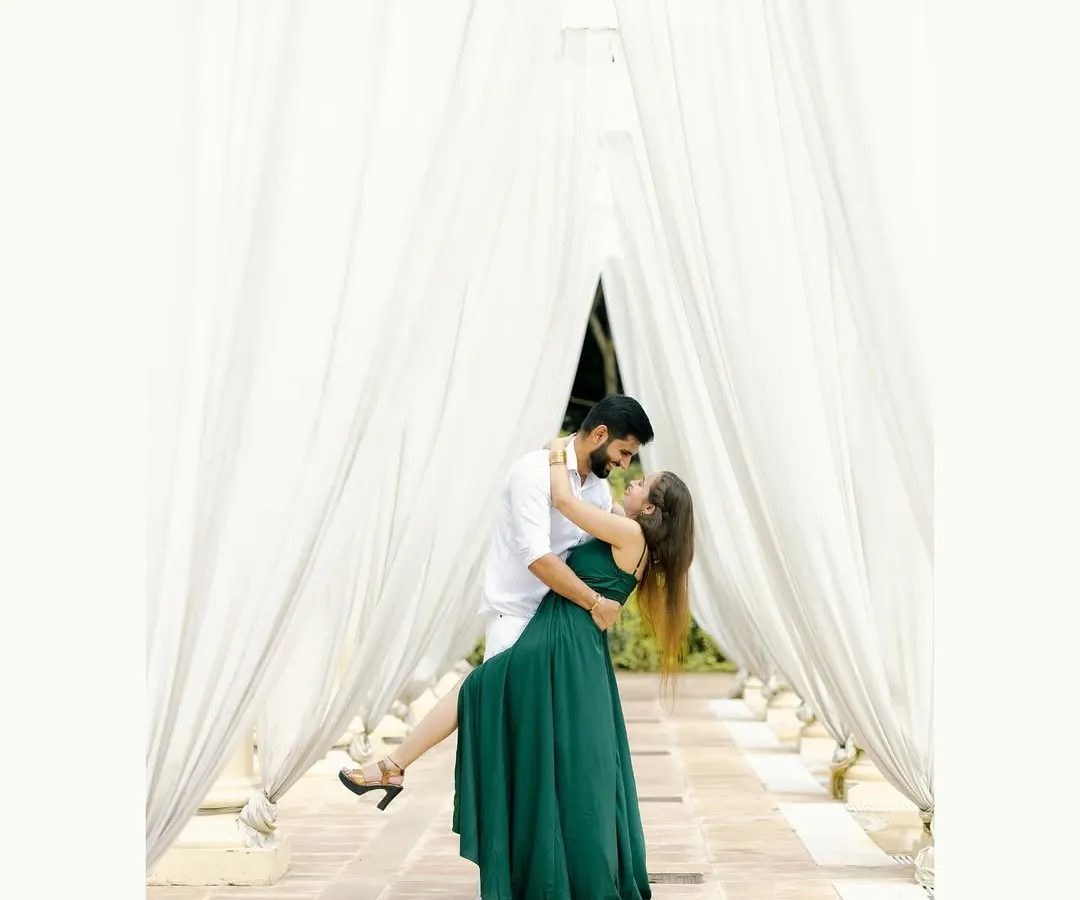 A timeless and romantic portrait of a couple sharing a gentle moment. The flowing white drapes create a dreamy, ethereal frame, perfect for a pre-wedding photoshoot that feels both classic and modern.