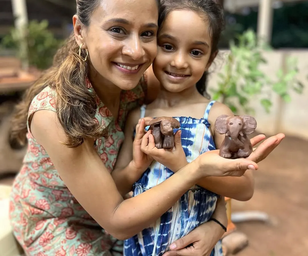 There is a special kind of magic when a parent and child create together. Here, a mother and daughter proudly show the little clay elephants they sculpted during a weekend family workshop.