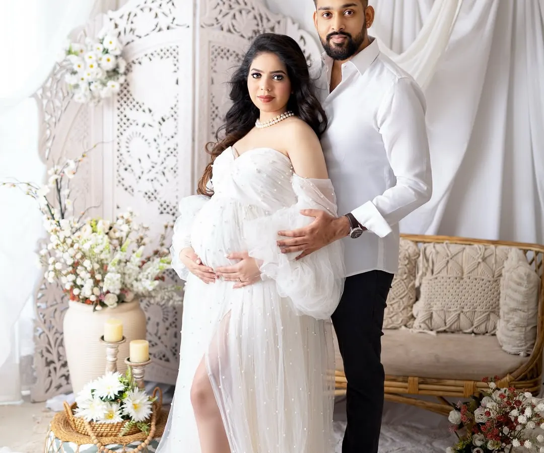 A glamorous mom-to-be celebrating her journey. I provide a collection of beautiful maternity gowns, like this elegant white dress, to make you feel absolutely radiant. This portrait was taken in my studio against a soft, dreamy backdrop.