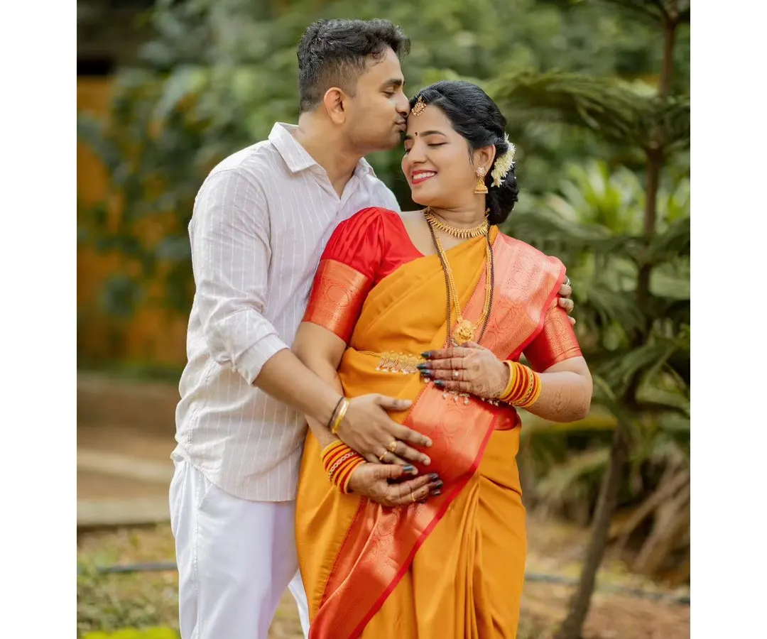 An intimate moment during an outdoor maternity photoshoot. We find that natural, green settings in places like Mangalore and Udupi help couples relax, allowing us to capture genuine affection and anticipation.